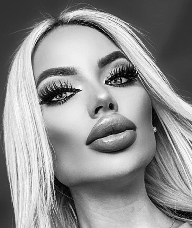 A black-and-white close-up of Sasha: long blonde hair, wispy lashes and full, glossy lips.