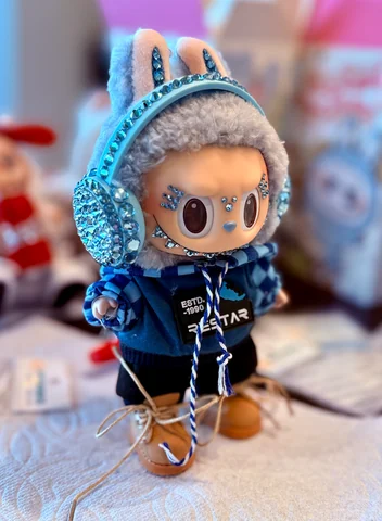 Labubu Nº 08: blue crystal headphones, a blue checked hoodie and suede boots.
