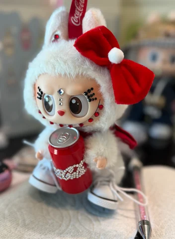 Labubu Nº 16: a red bow with a pom-pom, a crystal face and a cola can.
