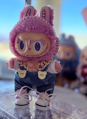 Labubu Nº 17: a lilac fluffy hood, a crystal chain and denim overalls.