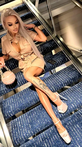 Sitting on the stairs in a beige mini dress.